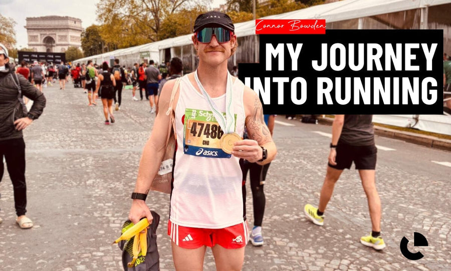 Runner showing a finisher medal and race bib near the Arc de Triomphe