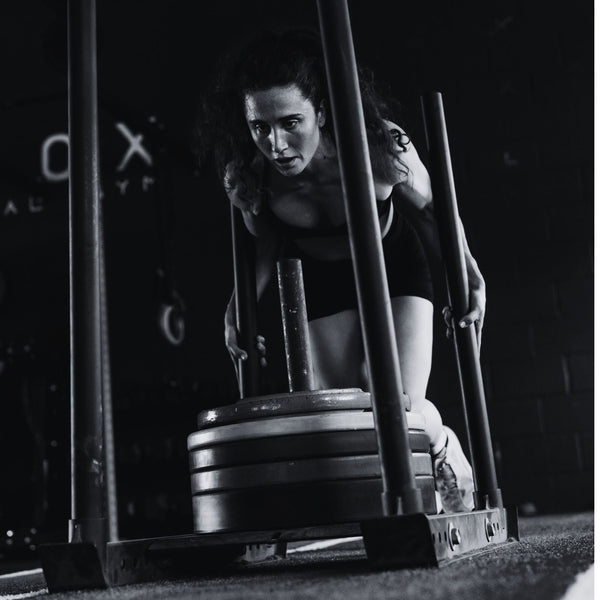 women pushing a sled in hyrox race 