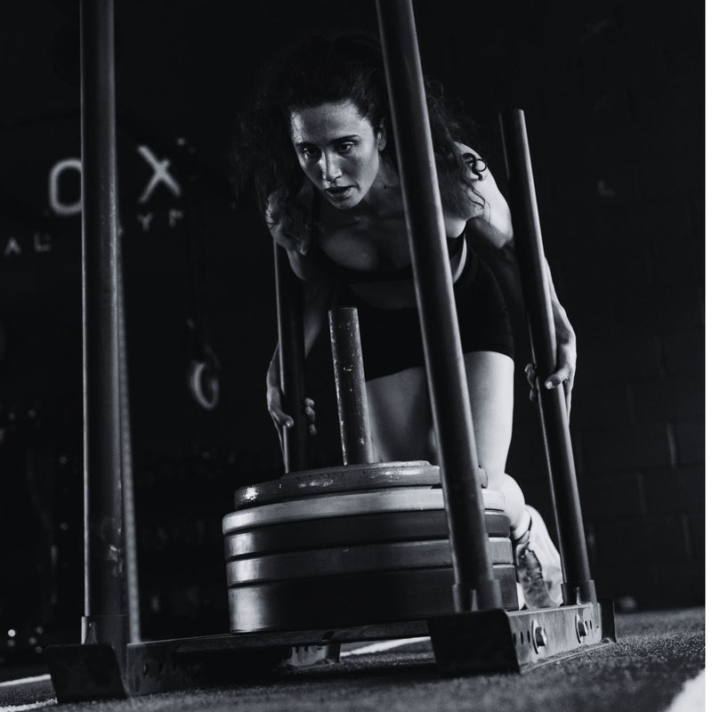 women pushing a sled in hyrox race 
